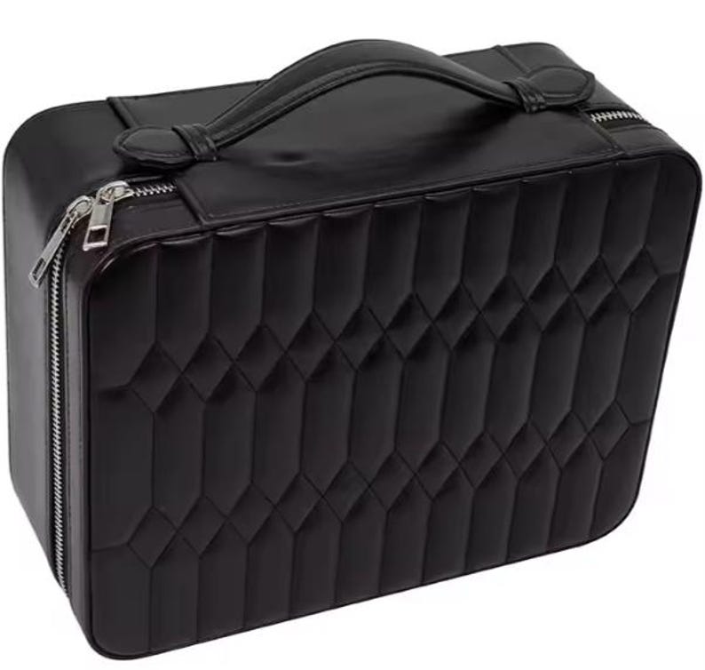 May include: Black quilted travel case with a zipper closure and a top handle.