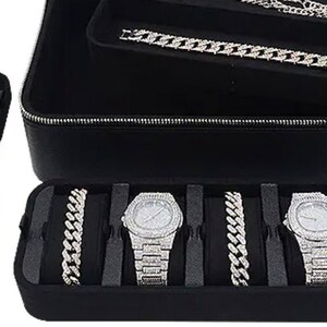 May include: Black leather case with multiple compartments for storing watches and jewelry. The case has a zipper closure and is lined with black velvet. The case is open and shows a variety of watches and chains with diamond accents.