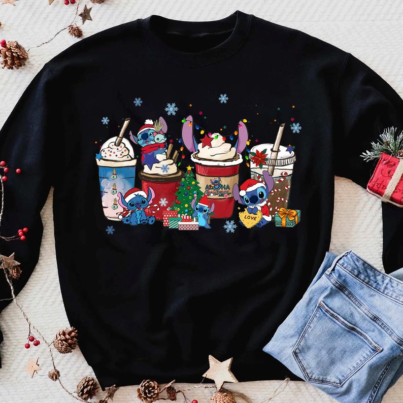 Peut inclure: Pull-over noir de No&euml;l avec un motif de personnages Stitch tenant des tasses de caf&eacute; et de chocolat chaud. Les tasses ont des motifs de No&euml;l et les personnages portent des bonnets de P&egrave;re No&euml;l. Le texte "Aloha Christmas" est sur l'une des tasses.
