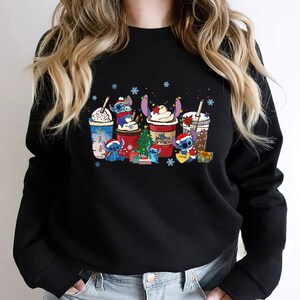 Peut inclure: Sweat-shirt noir avec un motif de No&euml;l repr&eacute;sentant des personnages de Stitch de Lilo & Stitch. Le motif montre des personnages de Stitch tenant diff&eacute;rentes boissons &agrave; th&egrave;me de No&euml;l, dont un latte au pain d'&eacute;pices, un moka &agrave; la menthe poivr&eacute;e et un chocolat chaud.