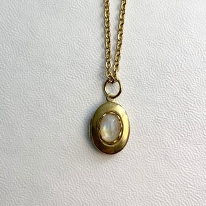 SMALL Antique brass LOCKET with Moonstone cabochon in a lace edged setting on 16" necklace.  Perfect for Layering.