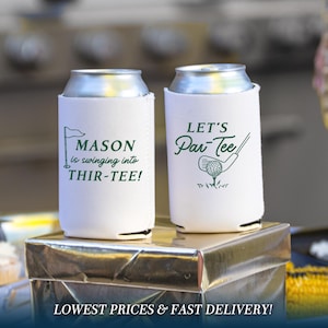 May include: Two white foam can coolers with green printed graphics. The left cooler features a golf flag and the text MASON is swinging into THIR-TEE! The right cooler displays a golf club, a ball, and the text LET'S Par-Tee in green ink.