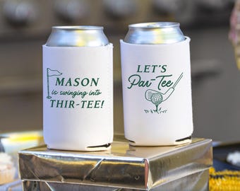 May include: Two white foam can coolers with green printed graphics. The left cooler features a golf flag and the text MASON is swinging into THIR-TEE! The right cooler displays a golf club, a ball, and the text LET'S Par-Tee in green ink.