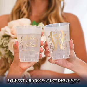 May include: Two clear plastic cups with gold lettering. One cup says "Ashley & William April 7, 2023". The other cup has a gold monogram.