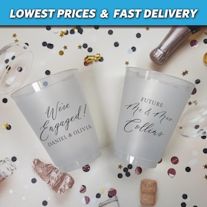 May include: Two clear plastic cups with black text. One cup says "We're Engaged! Daniel & Olivia". The other cup says "Future Mr. & Mrs. Collins".
