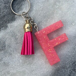 May include: Pink glitter letter F keychain with a pink tassel.
