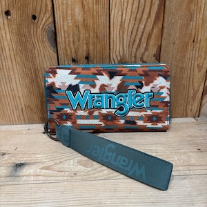May include: A wallet and wrist strap with the Wrangler logo. The wallet has a colorful geometric pattern in shades of brown, orange, and teal. The wrist strap is teal and has the Wrangler logo.