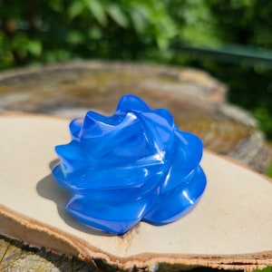 May include: A blue, swirl-shaped, resin sculpture with a glossy finish. The sculpture is made of multiple layers of resin, creating a unique and intricate design.