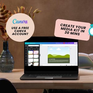 May include: A laptop computer with a Canva design program open on the screen. The screen shows a media kit template with the text "Synopsis" and a green landscape background. The laptop is on a wooden table with a vase of dried flowers and a book.
