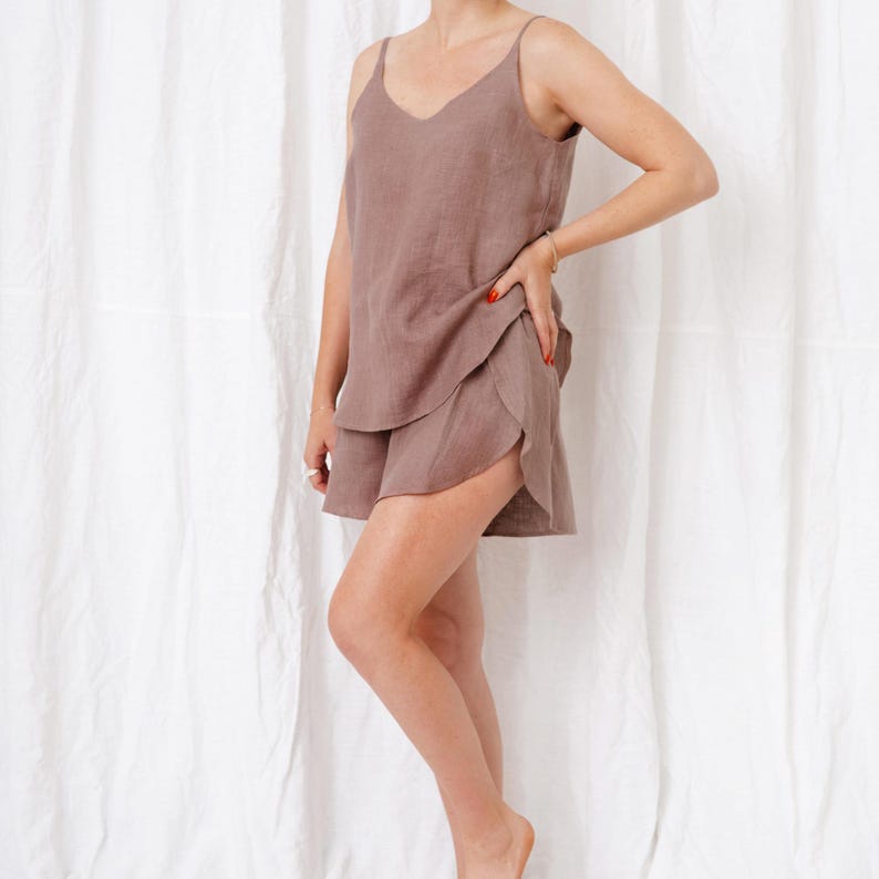 May include: A brown linen pajama set with a sleeveless top and shorts. The top has a V-neck and the shorts have a ruffled hem.