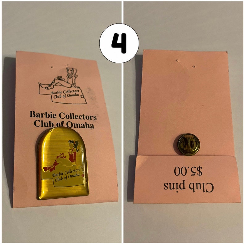 Op de afbeelding: Een gouden pin met een rood-witte afbeelding van een vrouw in een jurk. De pin is op een roze kaart met de tekst "Barbie Collectors Club of Omaha" en "Club pins &euro; 0,00".