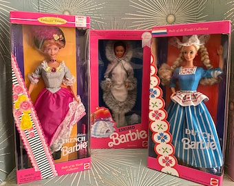 May include: Three Barbie dolls in their collector's edition boxes. The dolls are dressed in traditional clothing from France, the Netherlands, and the Arctic. The boxes feature the dolls' names and the text "Dolls of the World Collection".