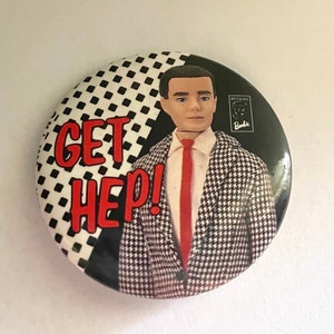 May include: A black and white button with a red and white checkered pattern. The button features a man in a black and white houndstooth suit with a red tie. The text "GET HEP!" is written in red letters on the button. The button also has a small logo that says "Nostalgic Barbie".