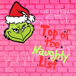 以下が含まれることがあります： ピンクのレンガの背景に、赤いサンタの帽子をかぶった緑色のグリンチのキャラクター。 「Top of the Naughty List」というテキストは、緑と赤の文字で書かれています。