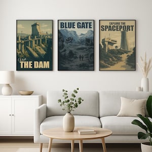 May include: Three framed vintage-style travel posters. The posters feature retro illustrations with text that reads "Visit The Dam", "Blue Gate", and "Explore the Spaceport". The posters are displayed above a white cabinet and a light gray sofa.