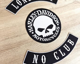 May include: Three black and white motorcycle patches. The top patch reads "LONE WOLF" in white, arched text. The center patch is a circular Harley-Davidson patch with a skull graphic. The bottom patch reads "NO CLUB" in white, arched text.