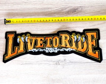 May include: A black embroidered patch with the words "LIVE TO RIDE" in orange with white claws on either side. The patch is approximately 28 inches wide.