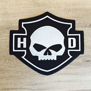 May include: Black and white embroidered patch with a skull and crossbones design. The patch features the letters "HD" in white on a black background.