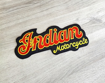 May include: A black patch featuring the words "Indian Motorcycle" in red and yellow. The text is in a vintage font, with a black border. The patch has a stylized design.