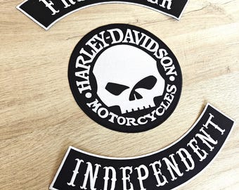 May include: Three black and white motorcycle patches. The top patch reads "FREE BIKER" in white, arched text. The center patch is a circle with a skull graphic and "HARLEY-DAVIDSON MOTORCYCLES" in white text. The bottom patch reads "INDEPENDENT" in white, arched text.