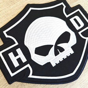 May include: Black and white embroidered patch with a skull and the letters "H-D" in a shield shape.