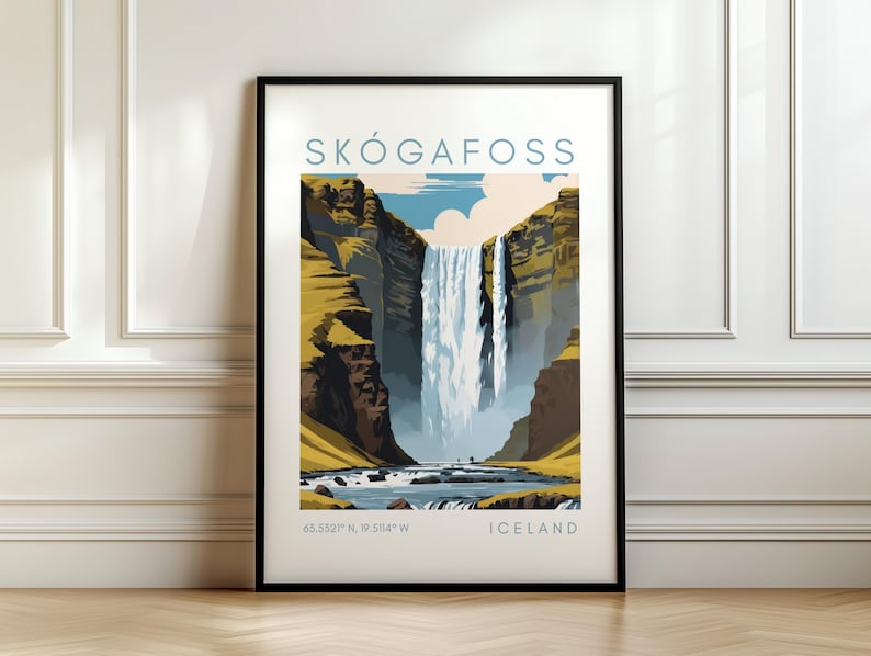 May include: Framed art print featuring a stylized illustration of Sk&oacute;gafoss waterfall in Iceland. The artwork displays the waterfall cascading down a cliff, with text that reads "SK&Oacute;GAFOSS" and "ICELAND". The print is in a black frame and rests on a wooden floor.