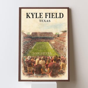 May include: A framed print depicting Kyle Field in Texas, rendered in a watercolour style. The image shows the stadium filled with spectators, with the text "KYLE FIELD TEXAS" at the top. The artwork captures the stadium's architecture and the atmosphere of a game.