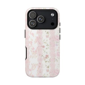 Puede incluir: Una funda de teléfono con un diseño floral. La funda presenta un fondo blanco con rayas verticales de encaje rosa y motivos florales. El área de la cámara es negra.