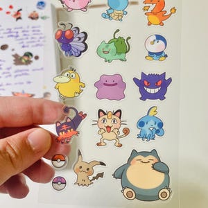 May include: A sheet of clear stickers featuring various Pokemon characters. The stickers are colorful and feature a variety of Pokemon, including Pikachu, Squirtle, Bulbasaur, and Charmander.