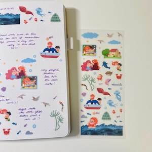 Puede incluir: Una hoja de pegatinas transparentes con ilustraciones coloridas de una familia de personajes pelirrojos disfrutando de un día en la playa. Las pegatinas incluyen un barco, una casa, un cangrejo, una medusa, un caballito de mar y una estrella de mar. Las pegatinas son perfectas para añadir un toque de fantasía a tu agenda, diario o álbum de recortes.