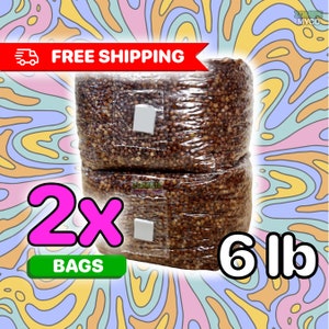 May include: Two 6-pound bags of brown grain substrate for mushroom cultivation. The bags are clear plastic and have a white label with the text "FREE SHIPPING" on a red banner.