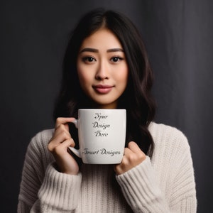 Blank mug, winter white coffee mug mock up, blank mug mockups, and images of a asian model in sweater holding a mug, face soft smile, 11 oz.