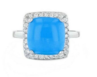 May include: A silver ring with a large, square, light blue gemstone surrounded by a halo of small, clear diamonds.