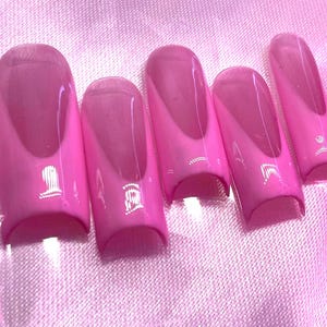 May include: Set of six pink and white false nails with a rounded tip and a curved shape.