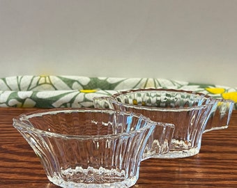 Peut inclure: Deux plats de service en verre transparent avec un motif cannelé. Les plats sont sur une surface en bois.