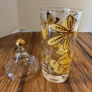 Vintage Apothecary Jar Painted Gold Yellow Fruit Design | Clear Glass Vanity Jar with Gold Knob Lid | Leaf Grape Cherry Decor