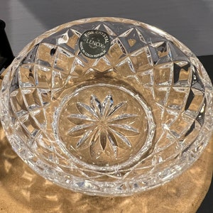 May include: A clear crystal bowl with a starburst pattern. The bowl has a label that reads "Fine Crystal Lenox Made in Czech Republic".