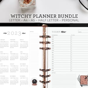 May include: A black and white planner with a 2023 calendar, a "TODAY" section with a schedule and to-do list, and a witchy theme with a crystal ball and a book with a moon and stars.