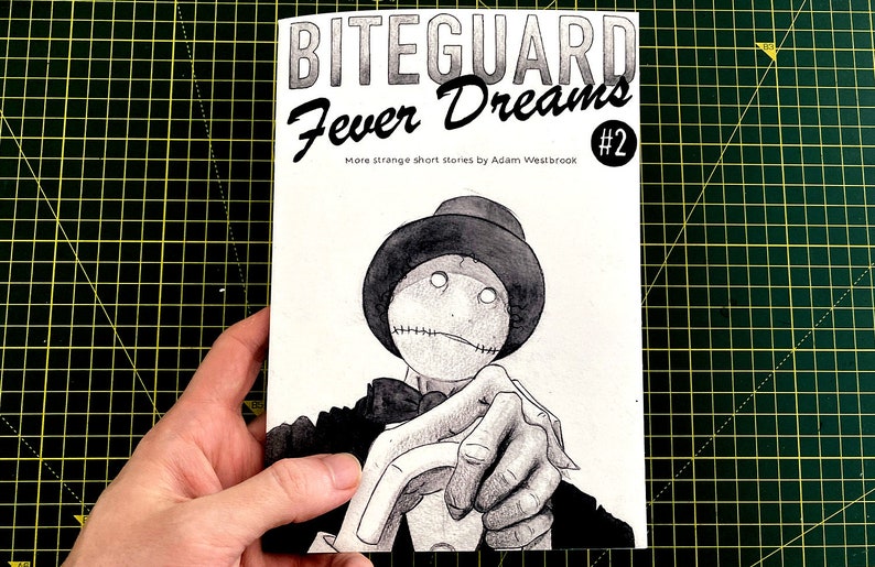 A photograph of a hand holding Biteguard Fever Dreams #2 by Adam Westbrook