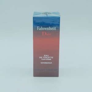 May include: A rectangular box of Fahrenheit Dior Eau de Toilette for men. The box has a gradient design, transitioning from a dark blue top to a red base. The product name and brand are printed in white and red.