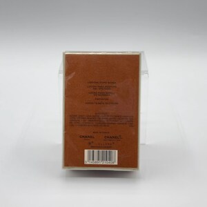 May include: A rectangular brown box with text in multiple languages, including "LONDON PARIS NEW YORK" and "PARFUM". The box is wrapped in clear plastic. The brand name "CHANEL" is visible on the bottom of the box.