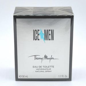 Op de afbeelding: Een zwarte en zilveren doos van Thierry Mugler Ice Men Eau de Toilette. De doos bevat de tekst "ICE MEN" met een blauwe ster, de merknaam en productdetails. Bevat 50 ml.
