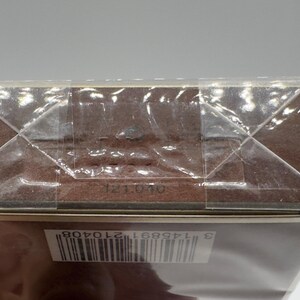 May include: A brown rectangular box sealed in clear plastic. The box has a barcode and the numbers "121040" printed on it. The box is sealed with clear tape.