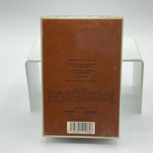 May include: A rectangular brown box of Chanel aftershave lotion. The box has text in multiple languages, including "Lotion Apr&egrave;s Barbe" and "Chanel". The bottom of the box has a barcode.