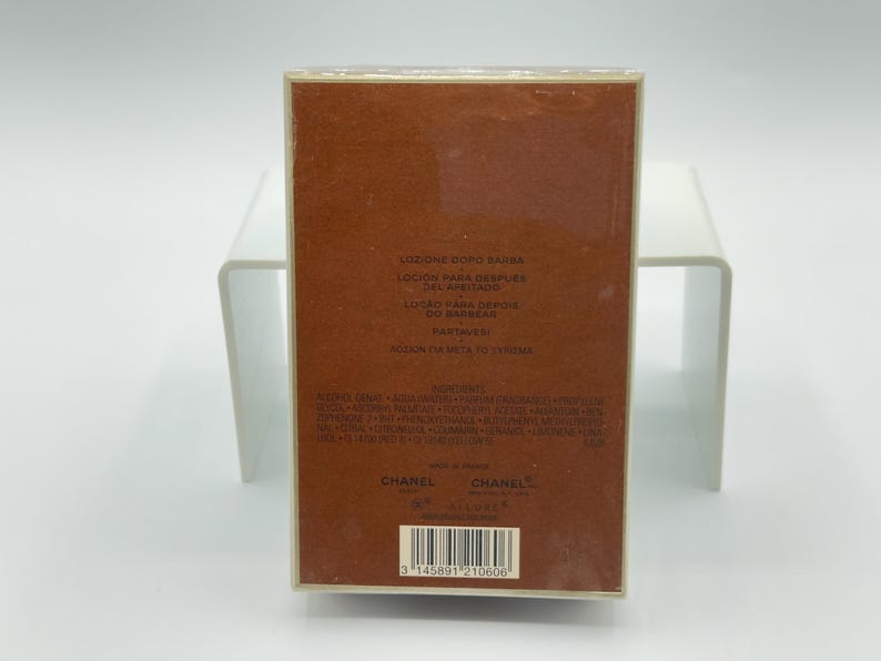 May include: A rectangular brown box of Chanel aftershave lotion. The box has text in multiple languages, including "Lotion Apr&egrave;s Barbe" and "Chanel". The bottom of the box has a barcode.