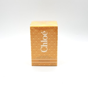 Puede incluir: Una caja de perfume rectangular con el nombre de la marca "Chloé" en letras blancas. La caja tiene un fondo cálido, amarillo anaranjado con un patrón circular repetitivo. La parte inferior de la caja dice "Parfums Chloé".