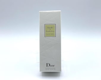 Puede incluir: Caja rectangular blanca de Eau de Toilette Dior "Escale à Pondichéry". La caja tiene un patrón geométrico y una etiqueta verde con el nombre del producto. La parte inferior de la caja tiene el logotipo de Dior y el volumen, 125 ml.