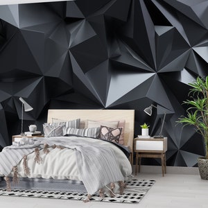May include: A bedroom interior design with a black and white geometric patterned rug, a bed with white bedding and a black and gray geometric patterned wallpaper.