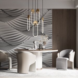 May include: A modern dining room with a white and gray patterned wall, a round wooden table, and four chairs. Two chairs are beige and two are black and white checkered. A gold and white pendant light hangs above the table.