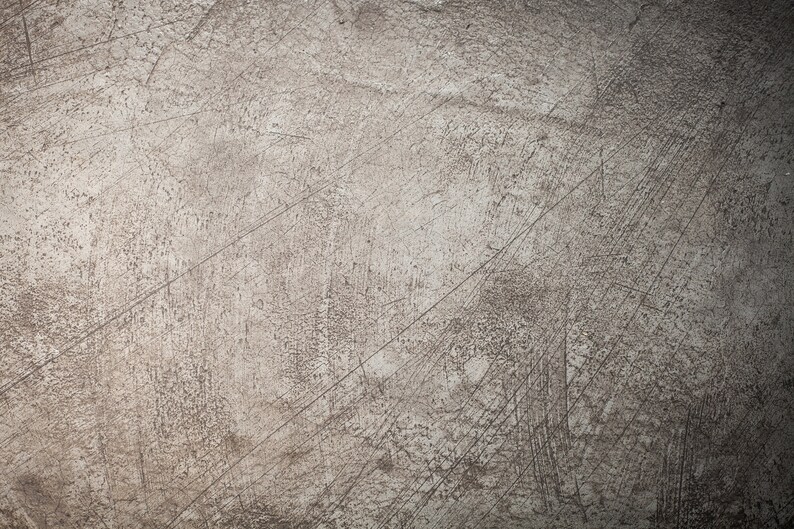 May include: A close-up of a textured, gray surface with a subtle, faded pattern. The surface has a worn, distressed look with visible scratches and marks.
